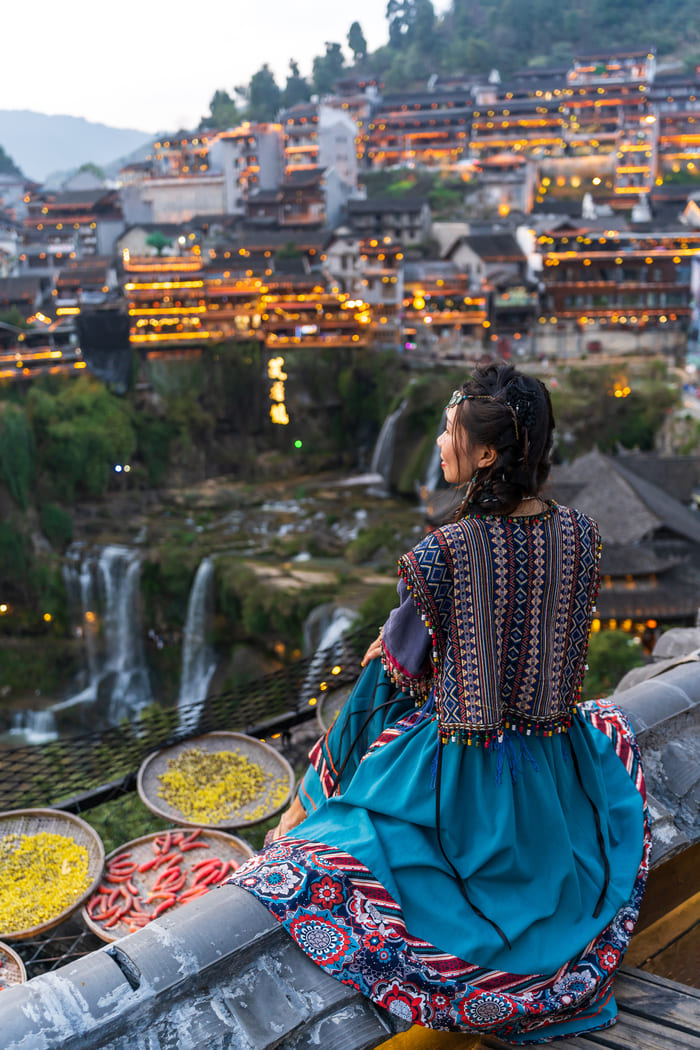 ciudad-lijiang de noche frente una mujer nativa