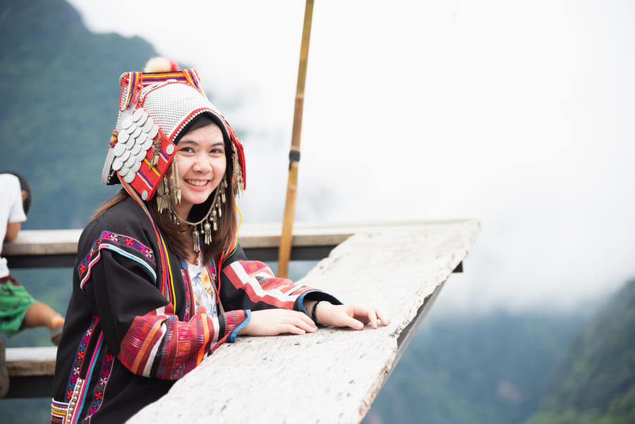 Joven mujer China con ropa Tipica frente a las montañas